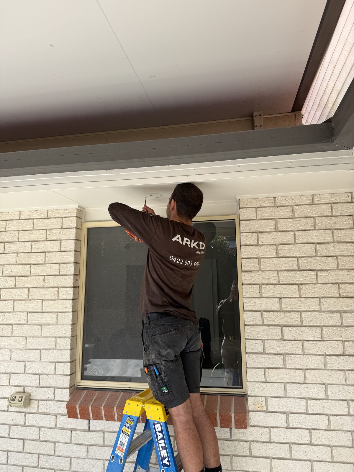 ARKD Electrical technician installing a downlight at a Brisbane home